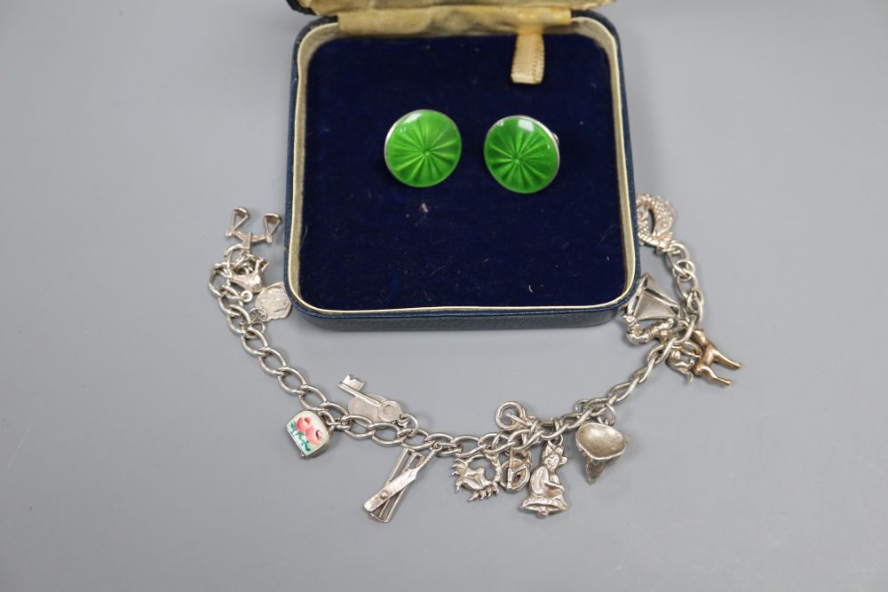 A pair of early George V silver and green enamel circular ear clips, 18mm and a modern white metal charm bracelet.